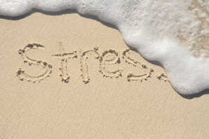 Stress written in sand with water washing it away